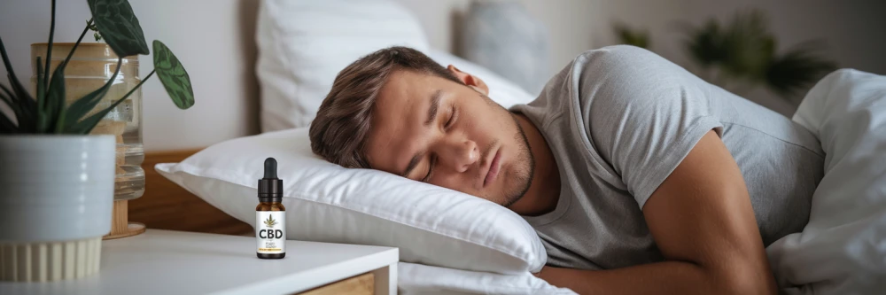 Photographie d'un homme dormant profondément dans une chambre confortable, avec une bouteille d'huile de CBD posée sur la table de nuit, illustrant les bienfaits du CBD sur le sommeil et la gestion des douleurs.